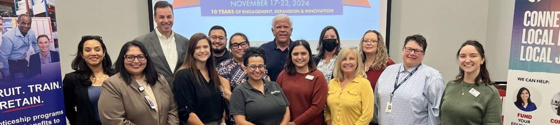 Group of professionals standing in front of NAW 2024 Logo